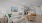 Open-concept living room and kitchen at The Portier Midtown Apartments featuring modern furnishings, warm wood flooring, sleek cabinetry, and stainless steel appliances for a stylish and inviting atmosphere.