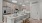 Modern luxury kitchen at The Portier Midtown Apartments featuring stainless steel appliances, sleek light wood cabinetry, quartz countertops, and a spacious island with barstool seating.