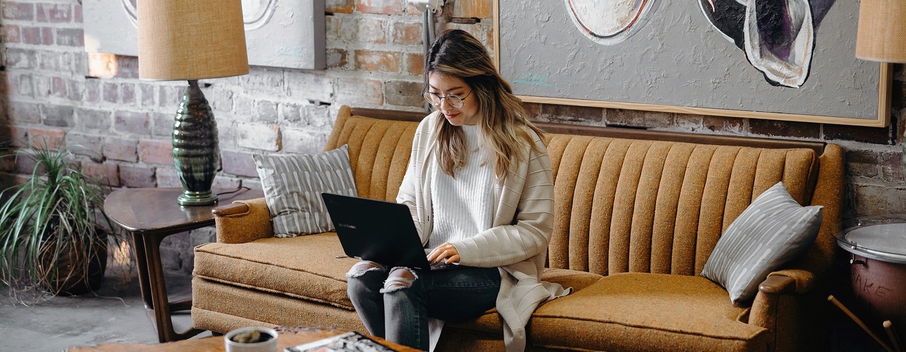 a woman sitting on a couch using a laptop
