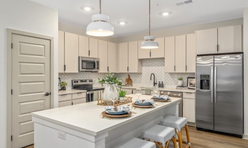Warm wood-grain Saco Seria kitchen cabinetry at The Portier Midtown